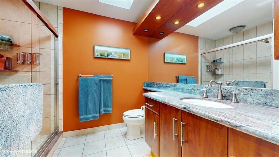 128 Cape Pointe Circle Jupiter, FL 33477 - Photo 25 of 42 a bathroom with a granite countertop sink a toilet a mirror and shower