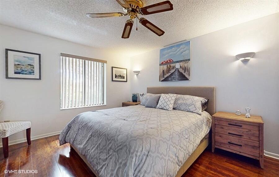 128 Cape Pointe Circle Jupiter, FL 33477 - Photo 26 of 42 a bedroom with a bed and wooden floor