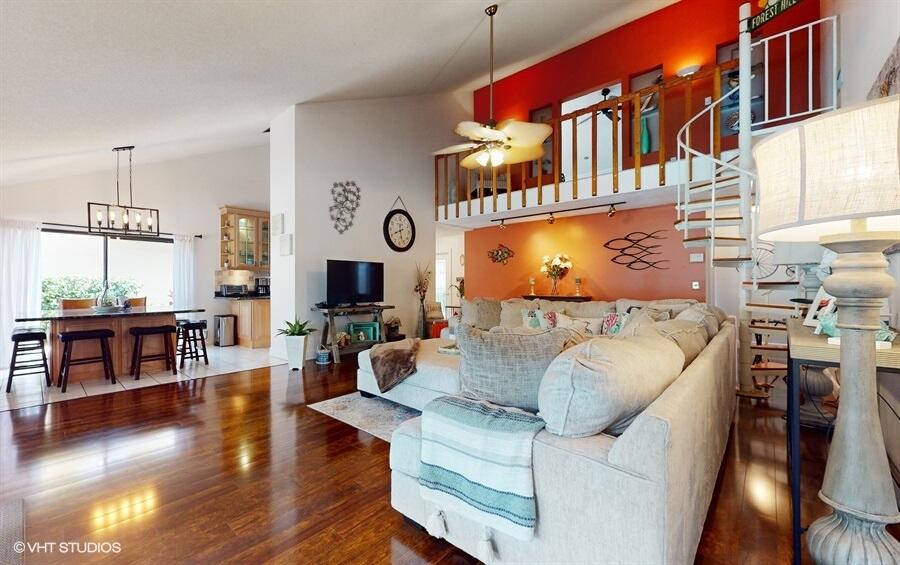 128 Cape Pointe Circle Jupiter, FL 33477 - Photo 6 of 42 a living room with furniture a wooden floor and a fireplace