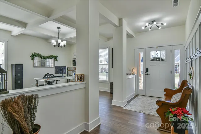 a kitchen with kitchen island stainless steel appliances a chandelier and living room view