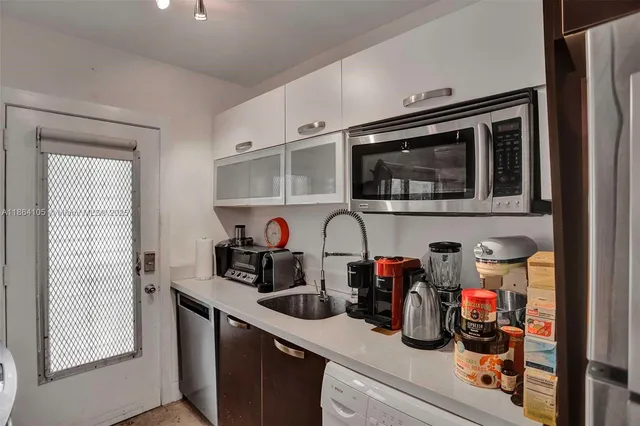 a kitchen with stainless steel appliances granite countertop a sink refrigerator and microwave