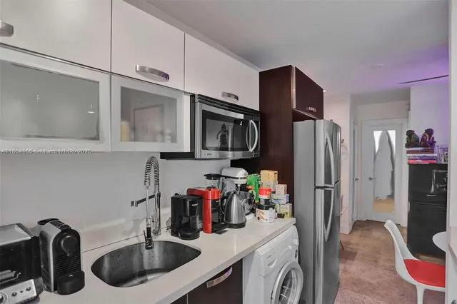 a kitchen with stainless steel appliances a refrigerator a stove top oven and cabinets