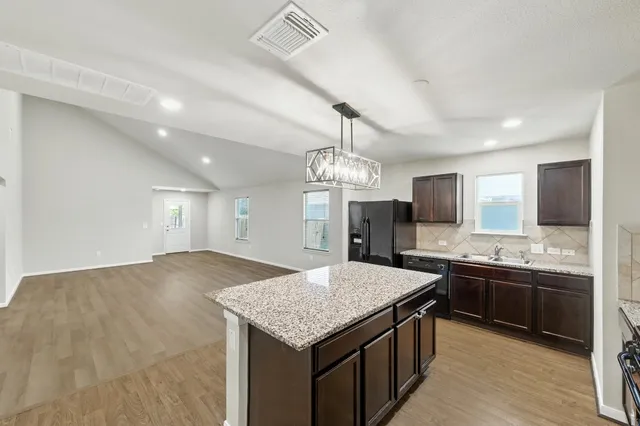 a kitchen with kitchen island granite countertop a sink and stove