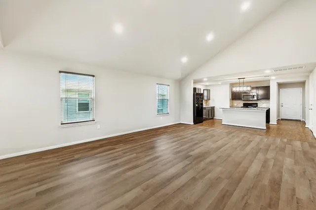 a view of empty room with wooden floor and window