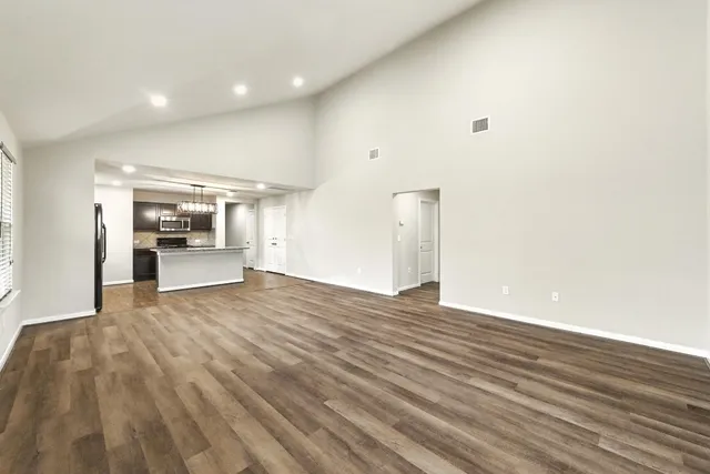 a view of an empty room and kitchen
