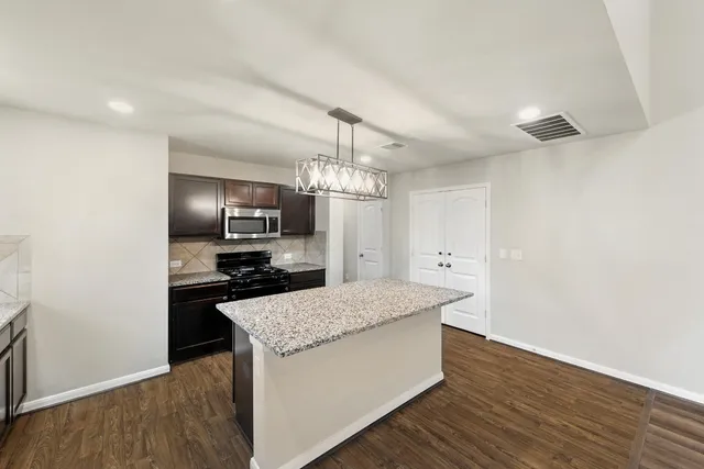 a kitchen with granite countertop counter top space a sink stainless steel appliances and cabinets