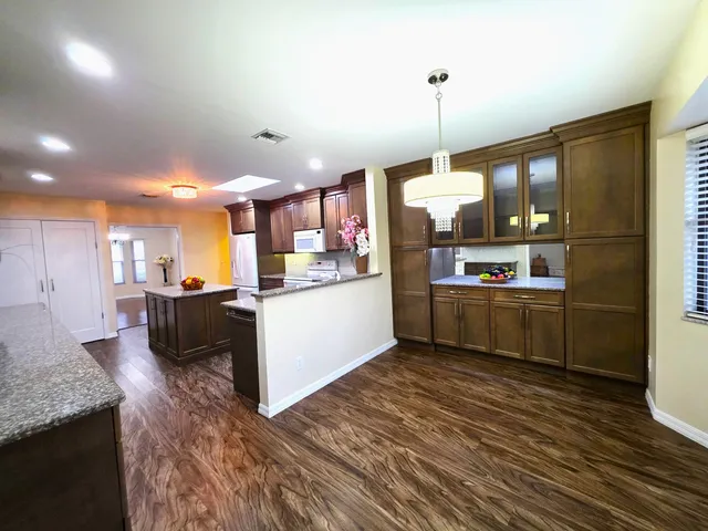 a kitchen with stainless steel appliances granite countertop a stove a sink and a refrigerator