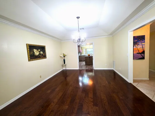 a view of a room with wooden floor and ceiling fan
