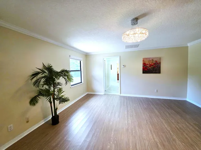 a view of empty room with wooden floor