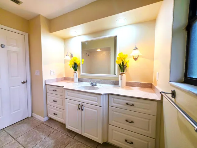 a spacious bathroom with a granite countertop sink and a mirror