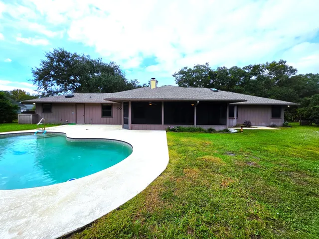 a view of a house with a yard and a tree