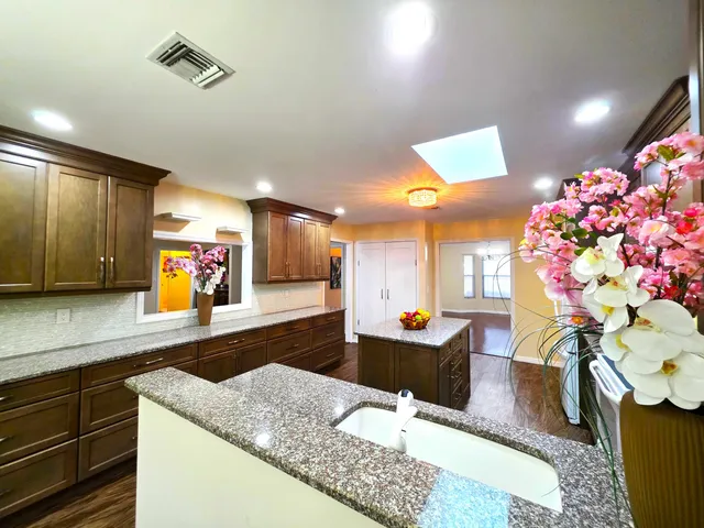 a kitchen with stainless steel appliances granite countertop wooden cabinets a stove top oven a sink and dishwasher