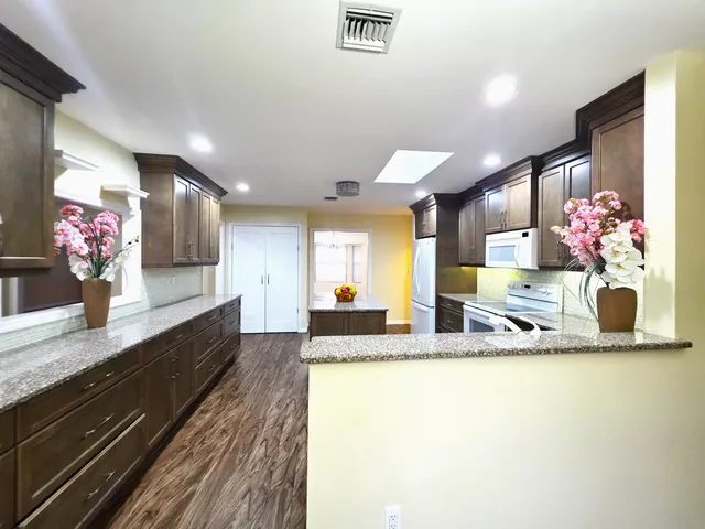 a view of a kitchen with stainless steel appliances granite countertop lots of counter top space