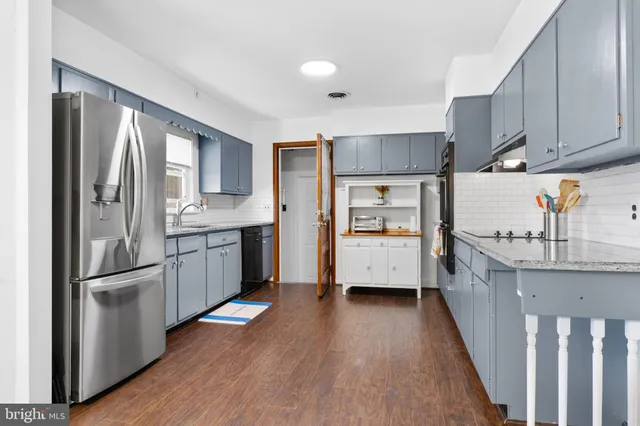 a kitchen with stainless steel appliances sink refrigerator and cabinets