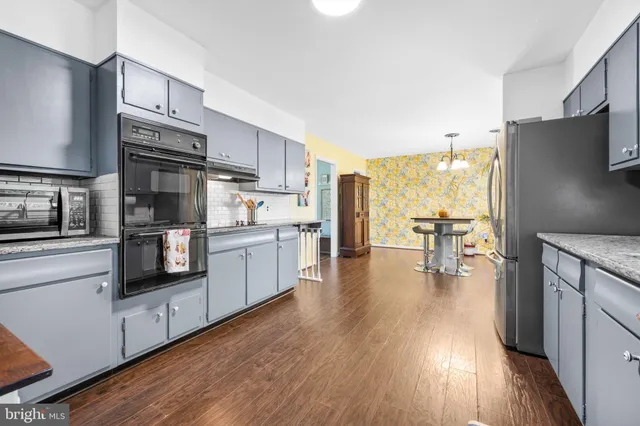a kitchen with stainless steel appliances a refrigerator and a stove top oven