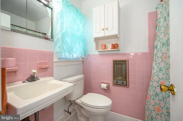 a bathroom with a sink a toilet and a mirror