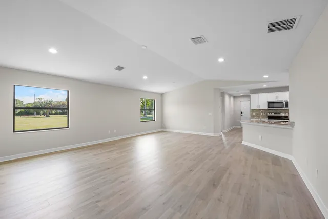 a view of a kitchen with wooden floor and a window
