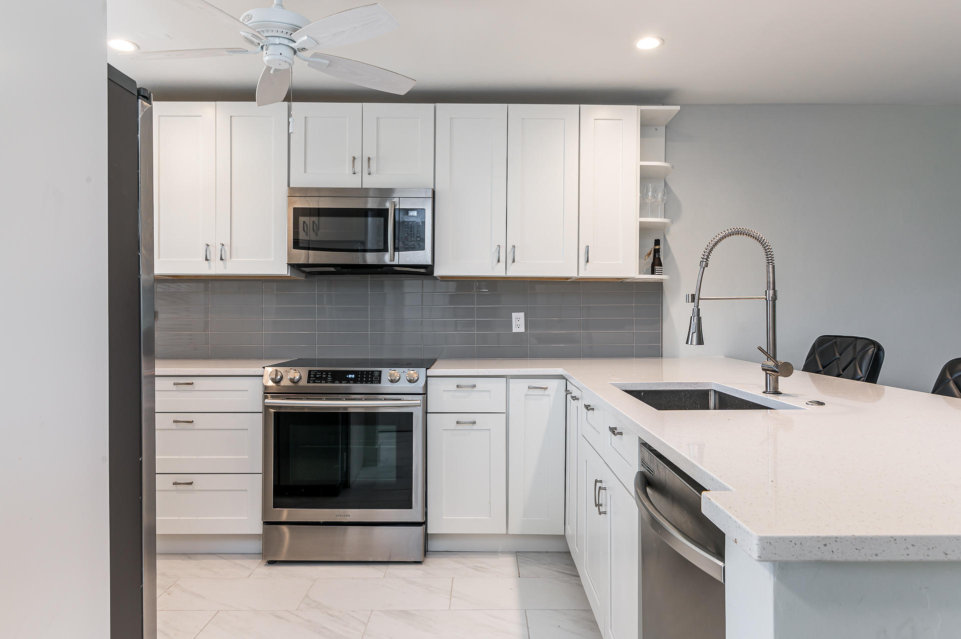 21856 Arriba Real, Unit 5E Boca Raton, FL 33433 - Photo 3 of 17 a kitchen with white cabinets stainless steel appliances and sink
