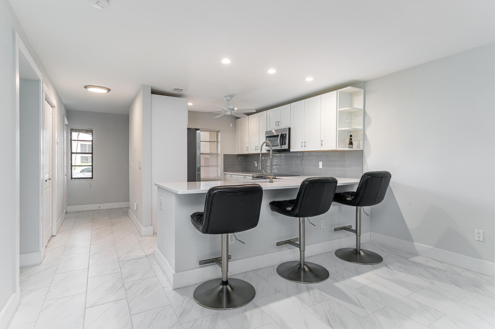 21856 Arriba Real, Unit 5E Boca Raton, FL 33433 - Photo 4 of 17 a kitchen with stainless steel appliances kitchen island granite countertop a refrigerator a stove a sink and white cabinets with wooden floor
