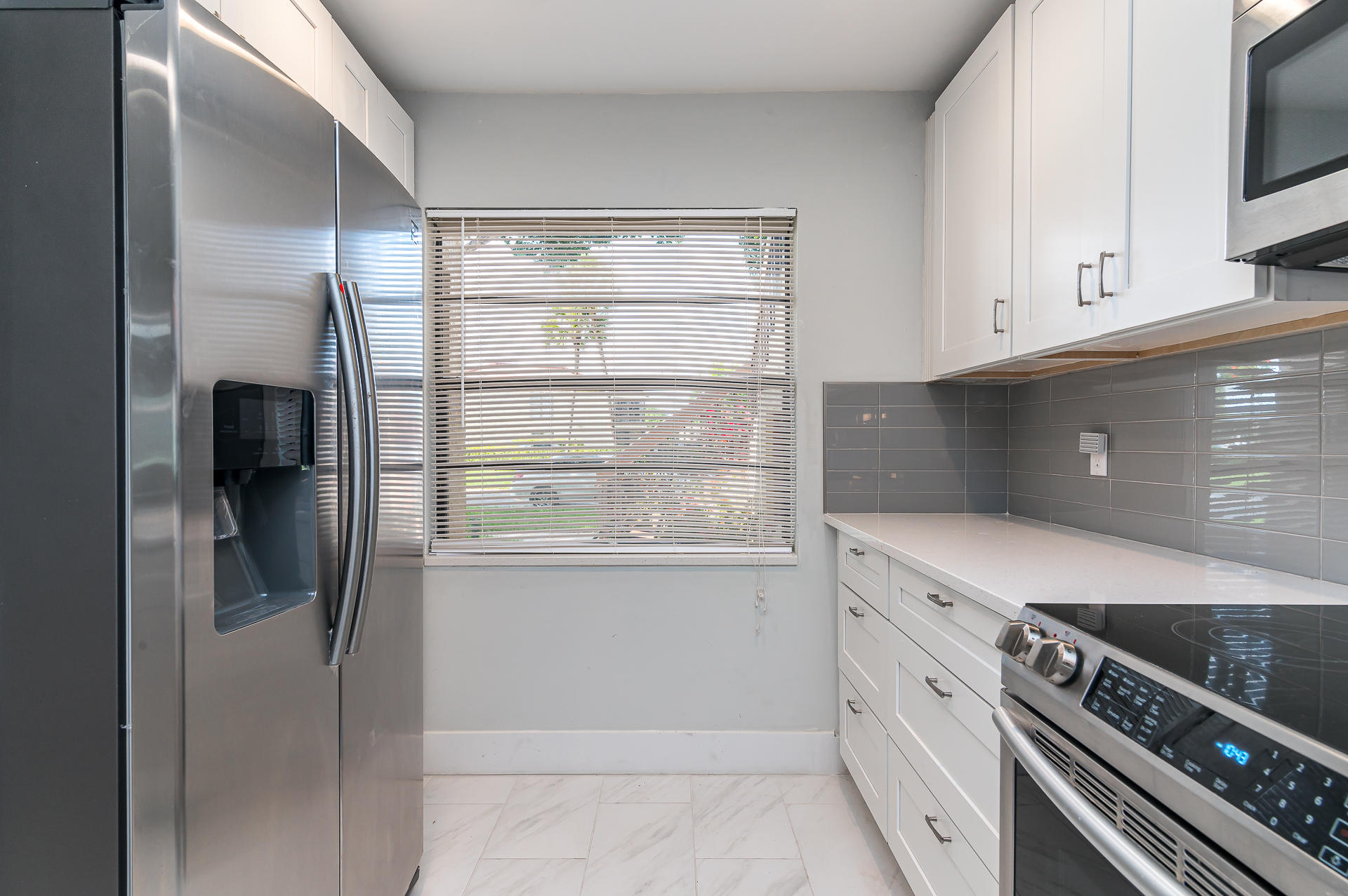 21856 Arriba Real, Unit 5E Boca Raton, FL 33433 - Photo 5 of 17 a kitchen with white cabinets and a stove top oven