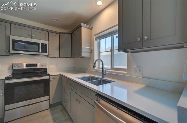 6604 Watusi Road Peyton, CO 80831 - Photo 11 of 40 Kitchen featuring stainless steel appliances, gray cabinetry, light countertops, and recessed lighting