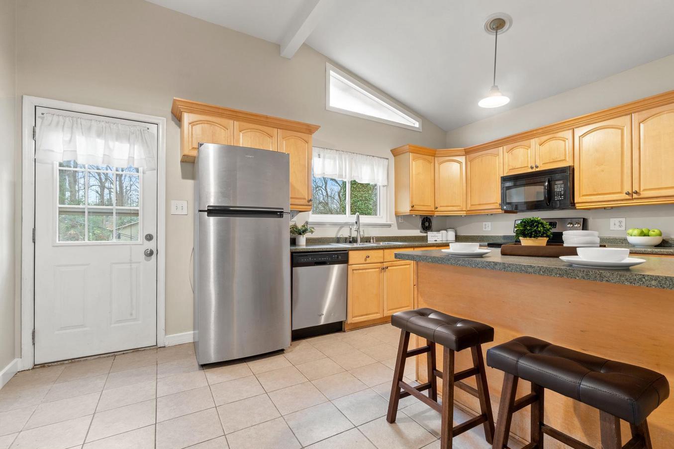 6505 Farley Street Springfield, VA 22152 - Photo 9 of 30 a kitchen with a refrigerator a microwave a stove cabinets dining table and chairs