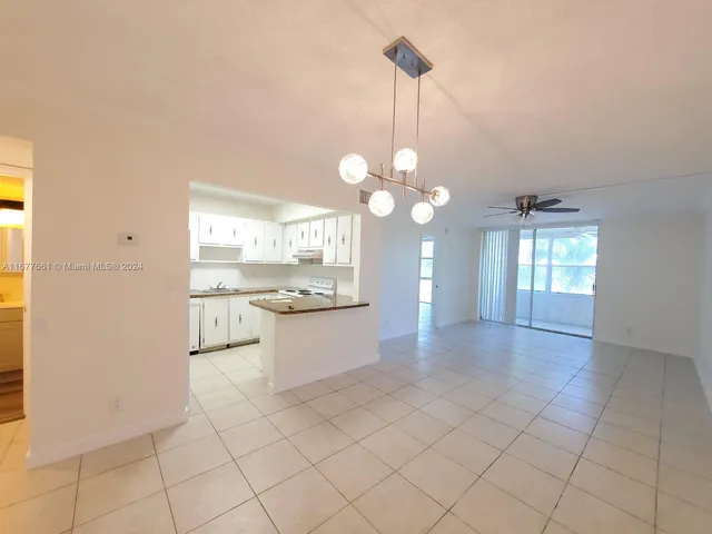 a view of a kitchen with granite countertop cabinets a sink and a chandelier