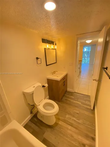 a spacious bathroom with a granite countertop sink a toilet and a mirror