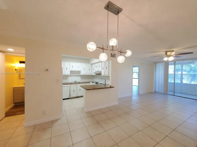 a view of a kitchen with a sink and chandelier