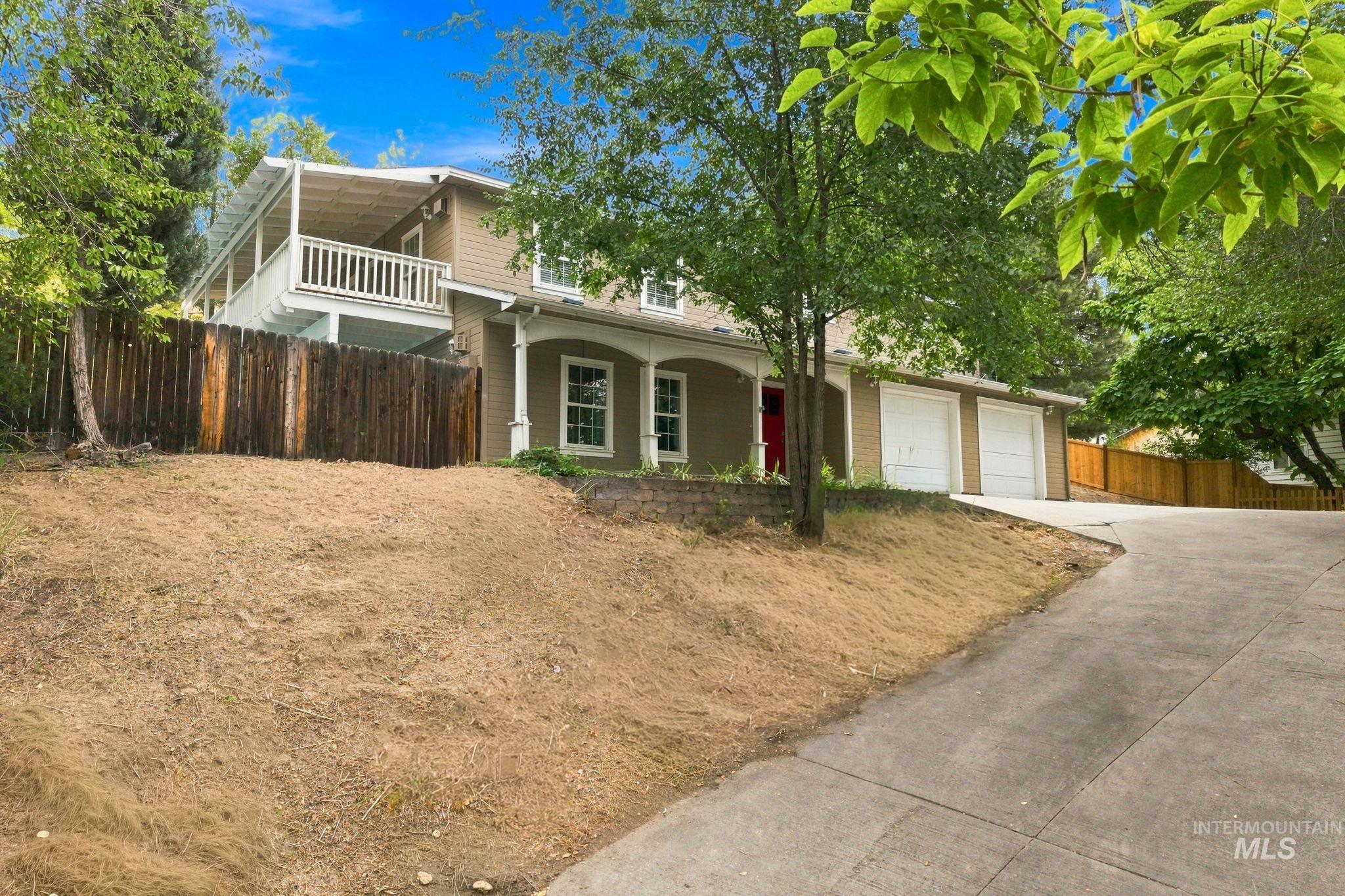 2442 West Hill Road Boise, ID 83702 - Photo 2 of 48 Two-car garage, upper-level balcony, front porch, and wood privacy fence