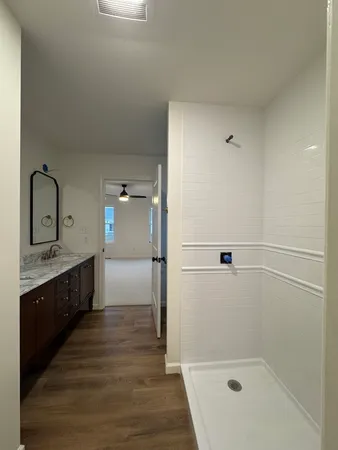 a bathroom with a granite countertop sink mirror and shower