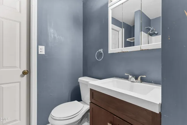 a bathroom with a sink a toilet and mirror