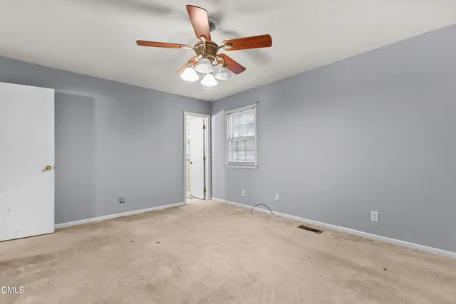 a view of an empty room with a chandelier fan
