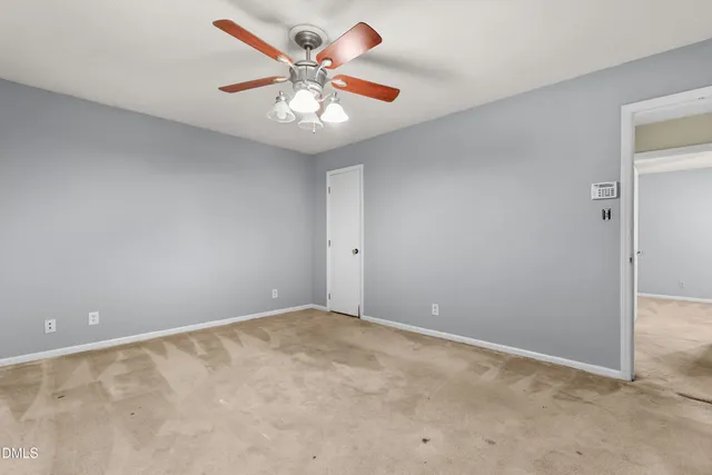 an empty room with chandelier fan