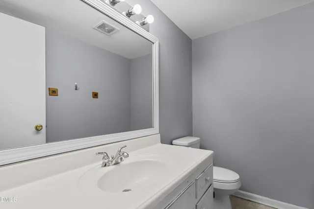 a bathroom with a sink a toilet and mirror