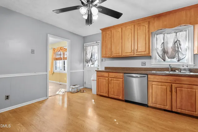 a open kitchen with granite countertop a sink cabinets and wooden floor