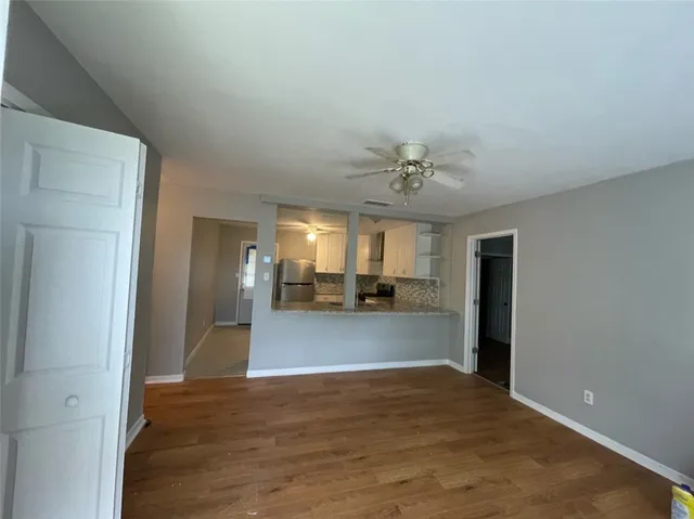 a view of empty room with wooden floor