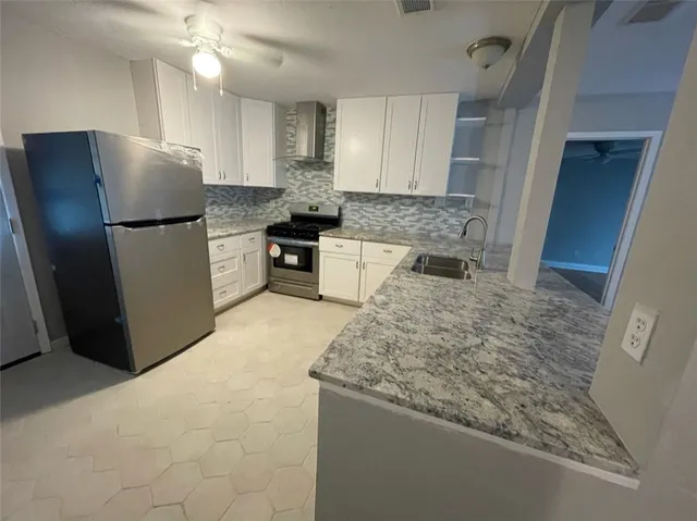 a kitchen with granite countertop a refrigerator and a sink