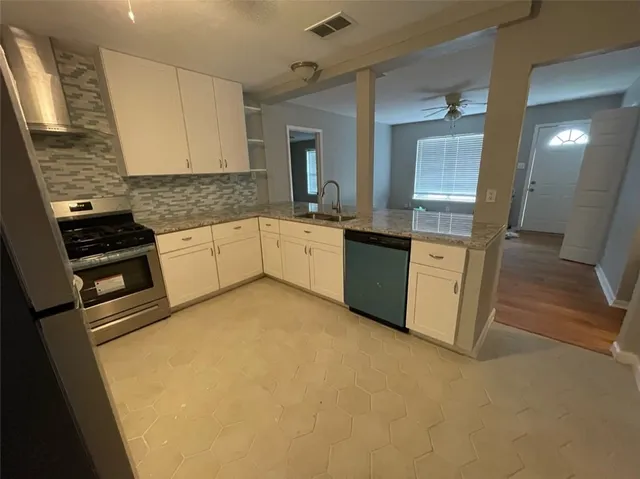 a large white kitchen with granite countertop a sink