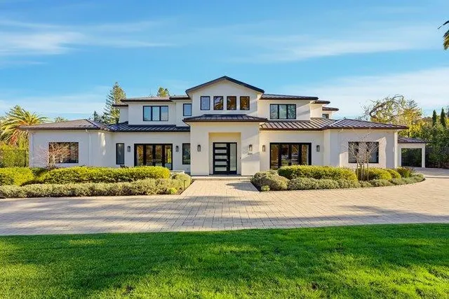 a front view of a house with yard and green space