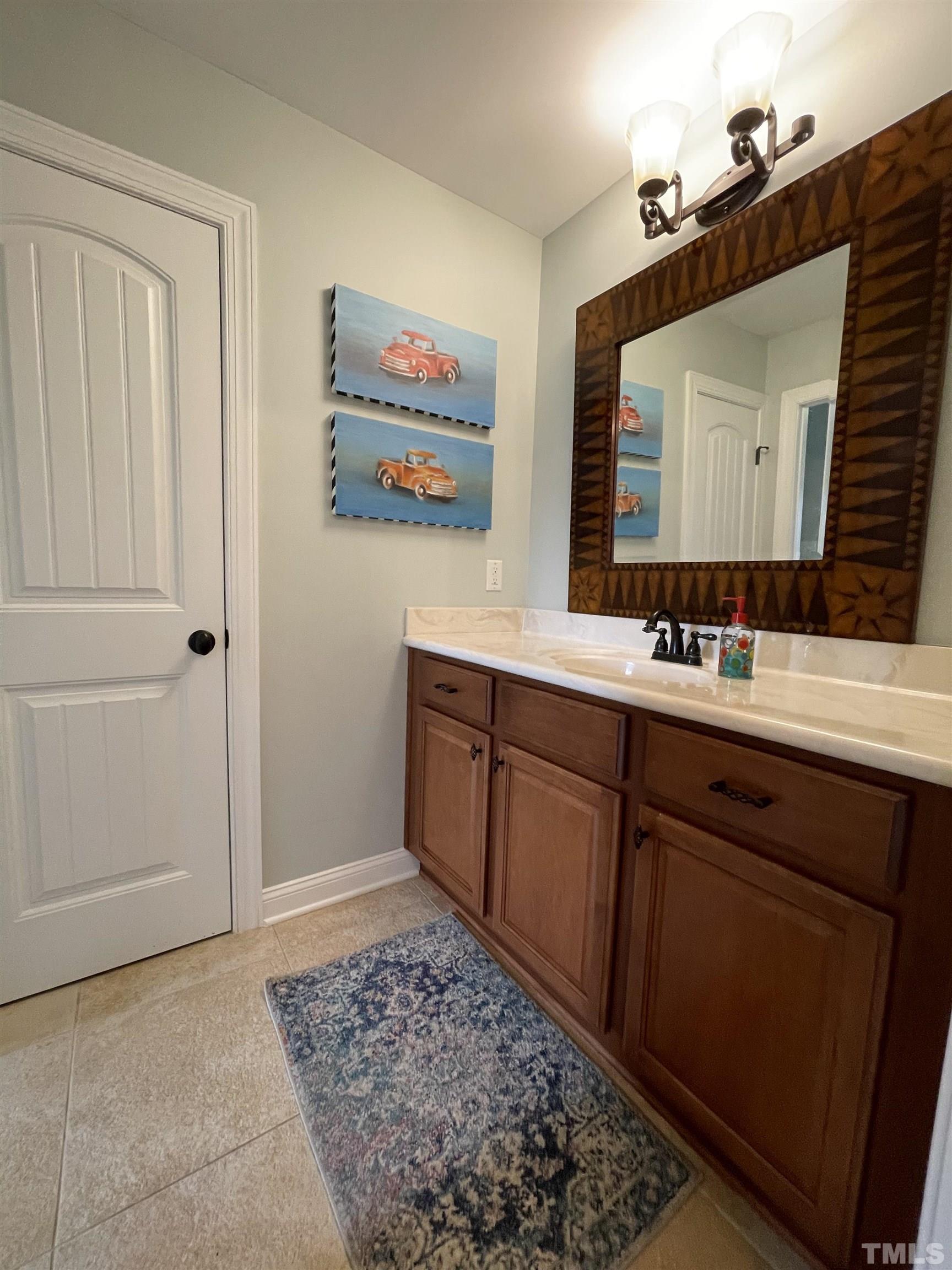 6228 Mitchell Mill Road Zebulon, NC 27597 - Photo 33 of 51 a bathroom with a sink and a mirror