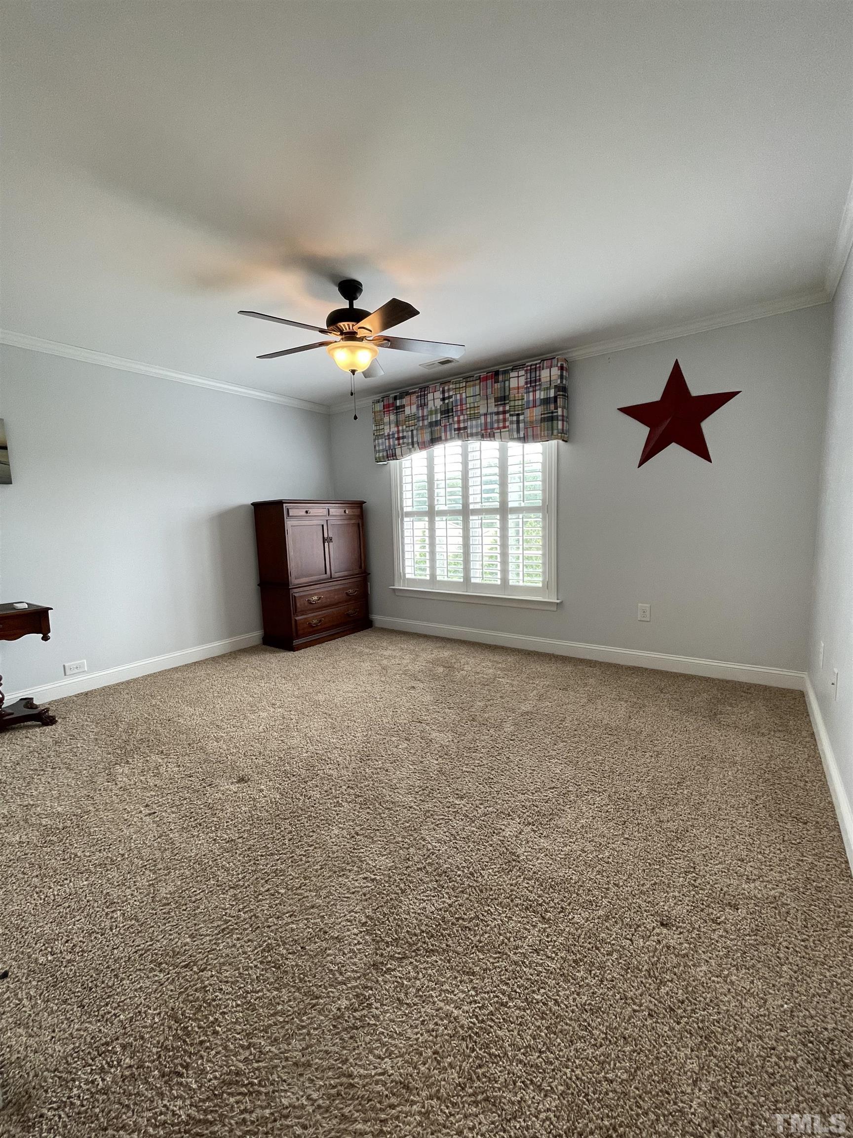 6228 Mitchell Mill Road Zebulon, NC 27597 - Photo 38 of 51 an empty room with windows and chandelier fan