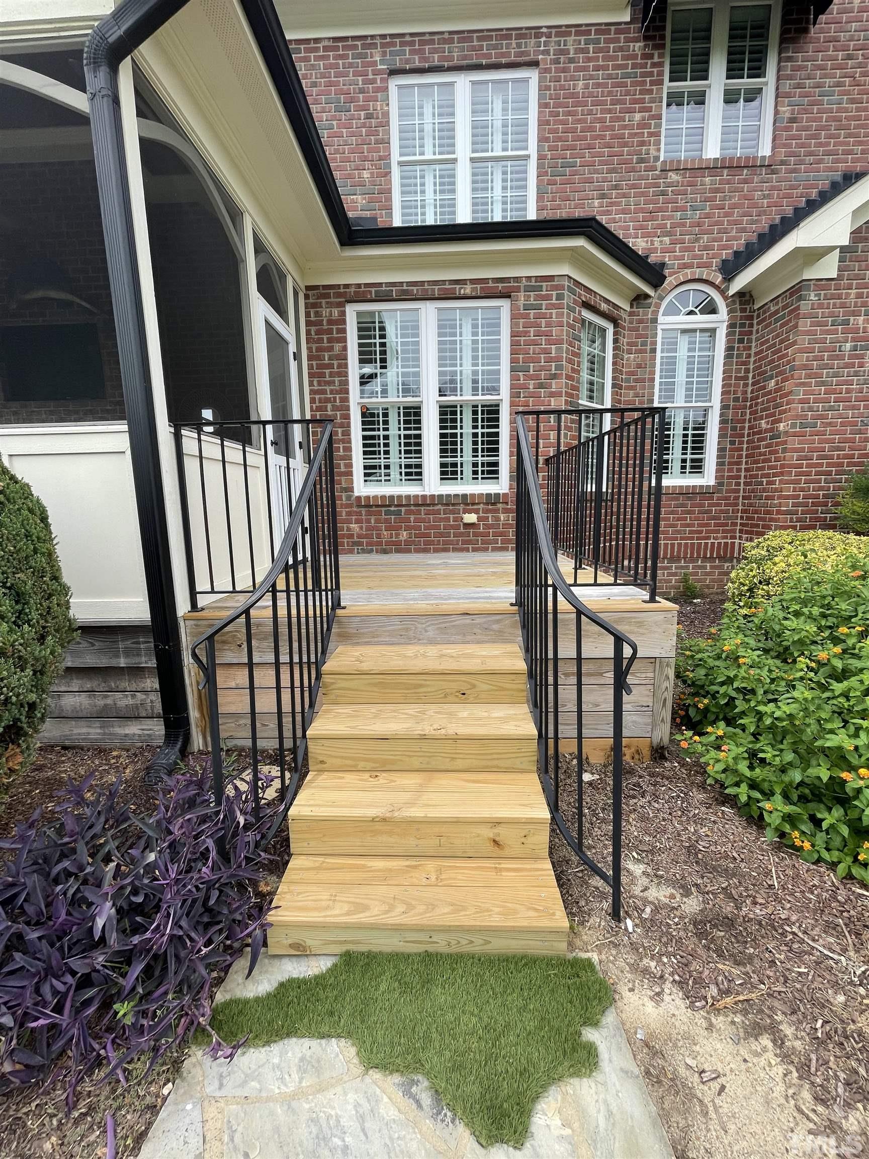6228 Mitchell Mill Road Zebulon, NC 27597 - Photo 44 of 51 a view of a brick house with wooden floor and a floor to ceiling window