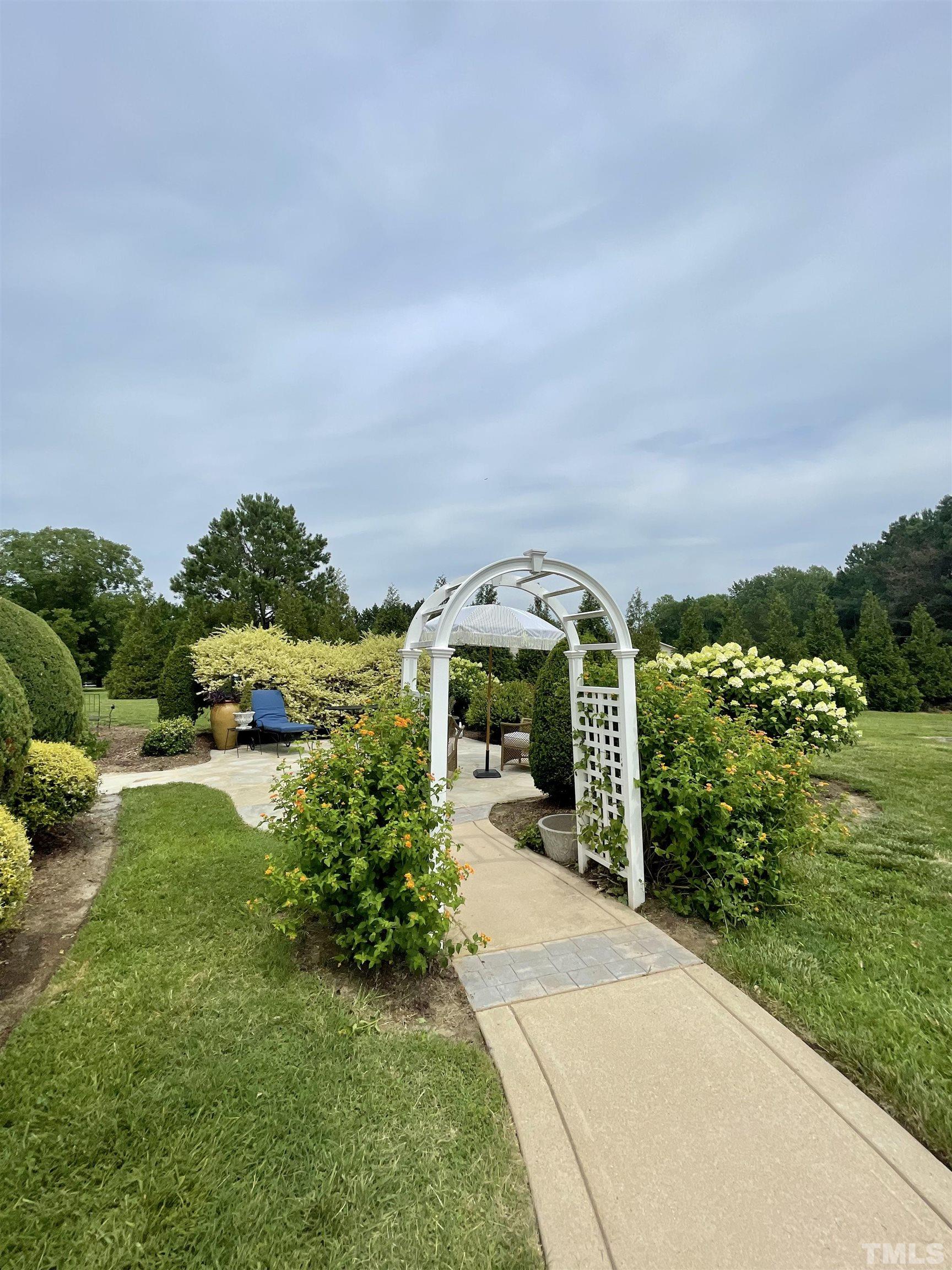 6228 Mitchell Mill Road Zebulon, NC 27597 - Photo 45 of 51 a view of a garden with a building in the background