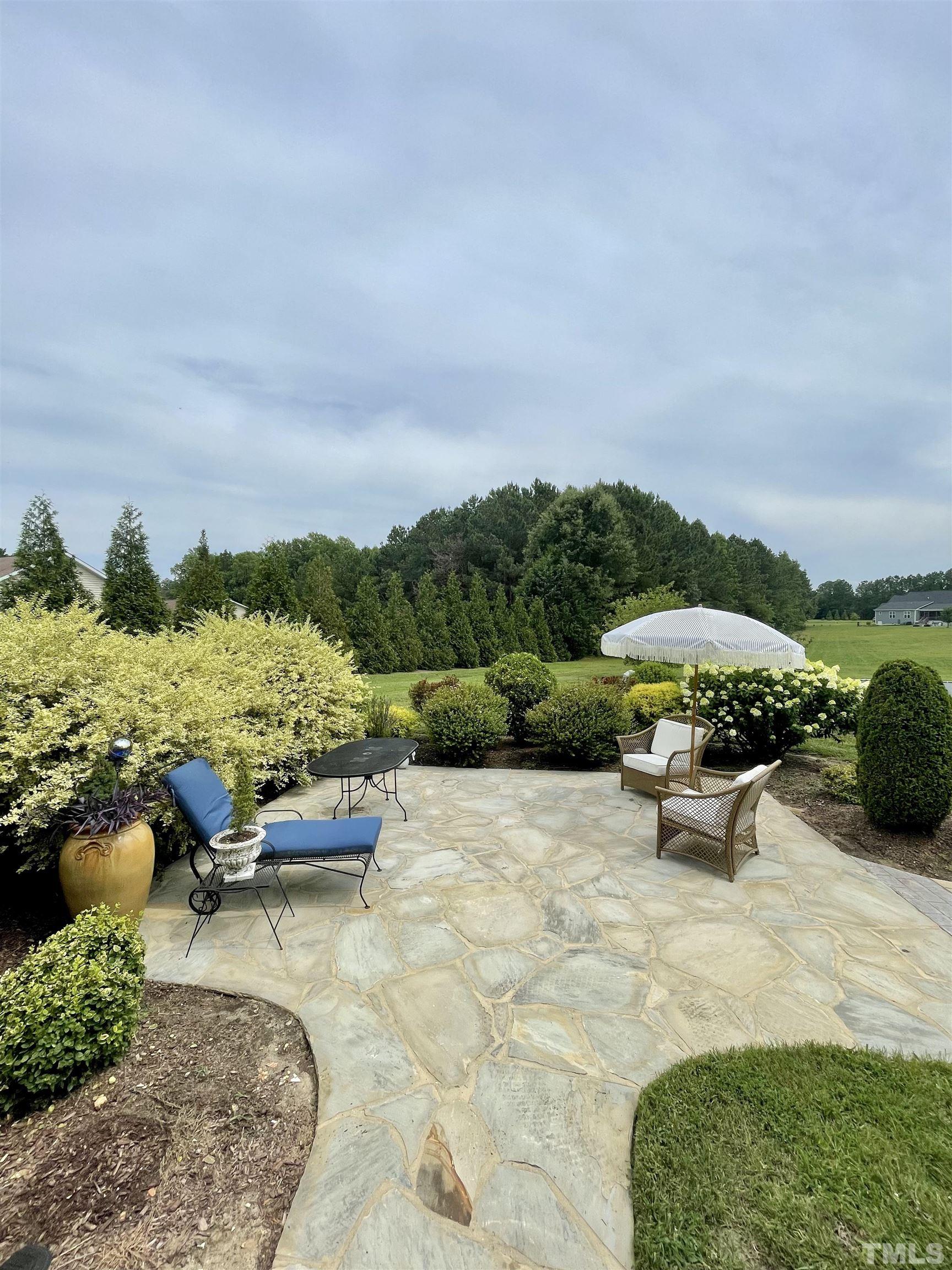 6228 Mitchell Mill Road Zebulon, NC 27597 - Photo 47 of 51 a view of a patio with a table and chairs under an umbrella