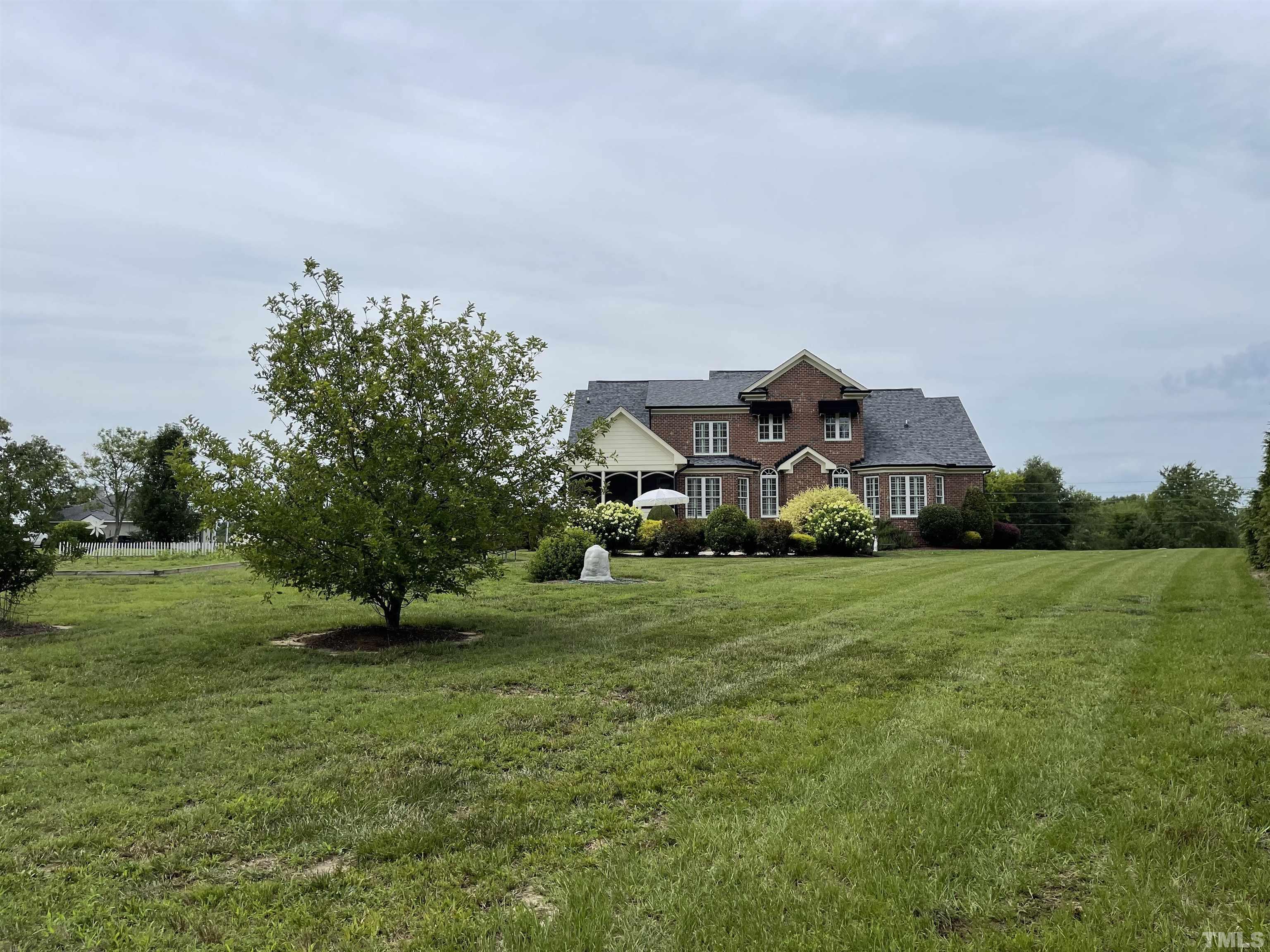 6228 Mitchell Mill Road Zebulon, NC 27597 - Photo 51 of 51 a view of a big house with a big yard and large trees
