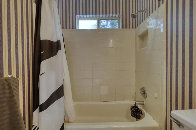 a bathroom with a shower and a bath tub