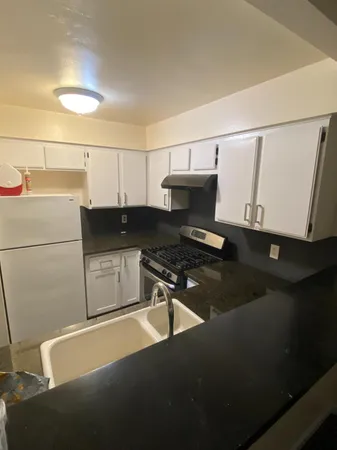 a kitchen with stainless steel appliances a stove a sink and a microwave