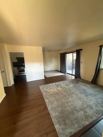 a view of an empty room with a fireplace and a window
