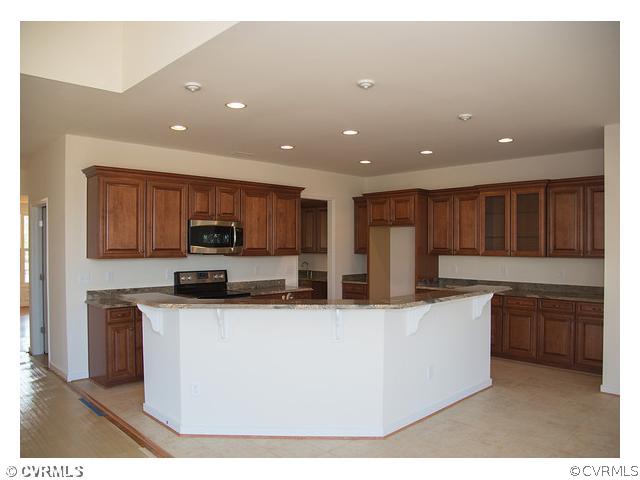 1246 Coalfield Road Midlothian, VA 23114 - Photo 3 of 5 a kitchen with stainless steel appliances kitchen island granite countertop a stove top oven a sink and a granite counter tops